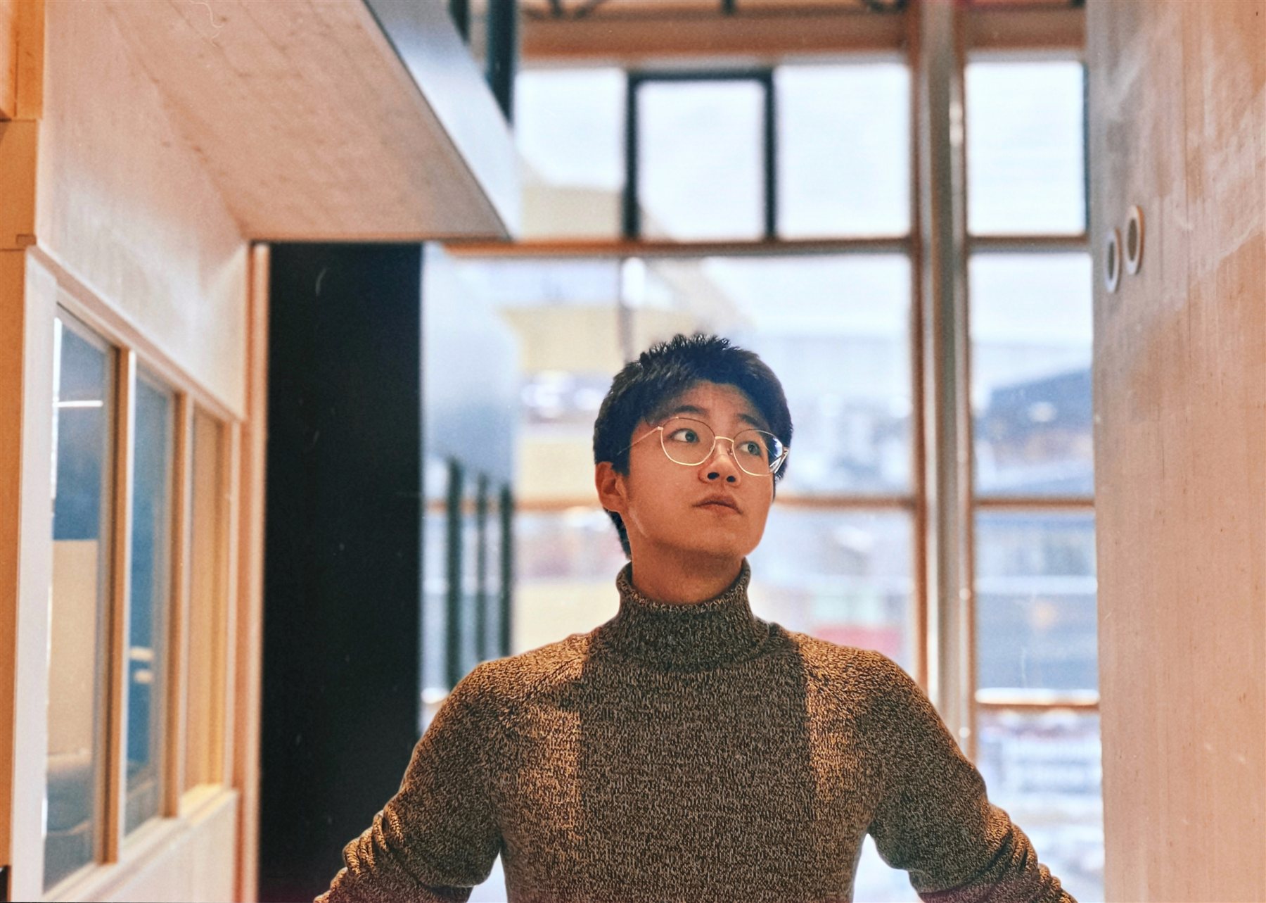 Siyuan standing inside a wooden architectural space